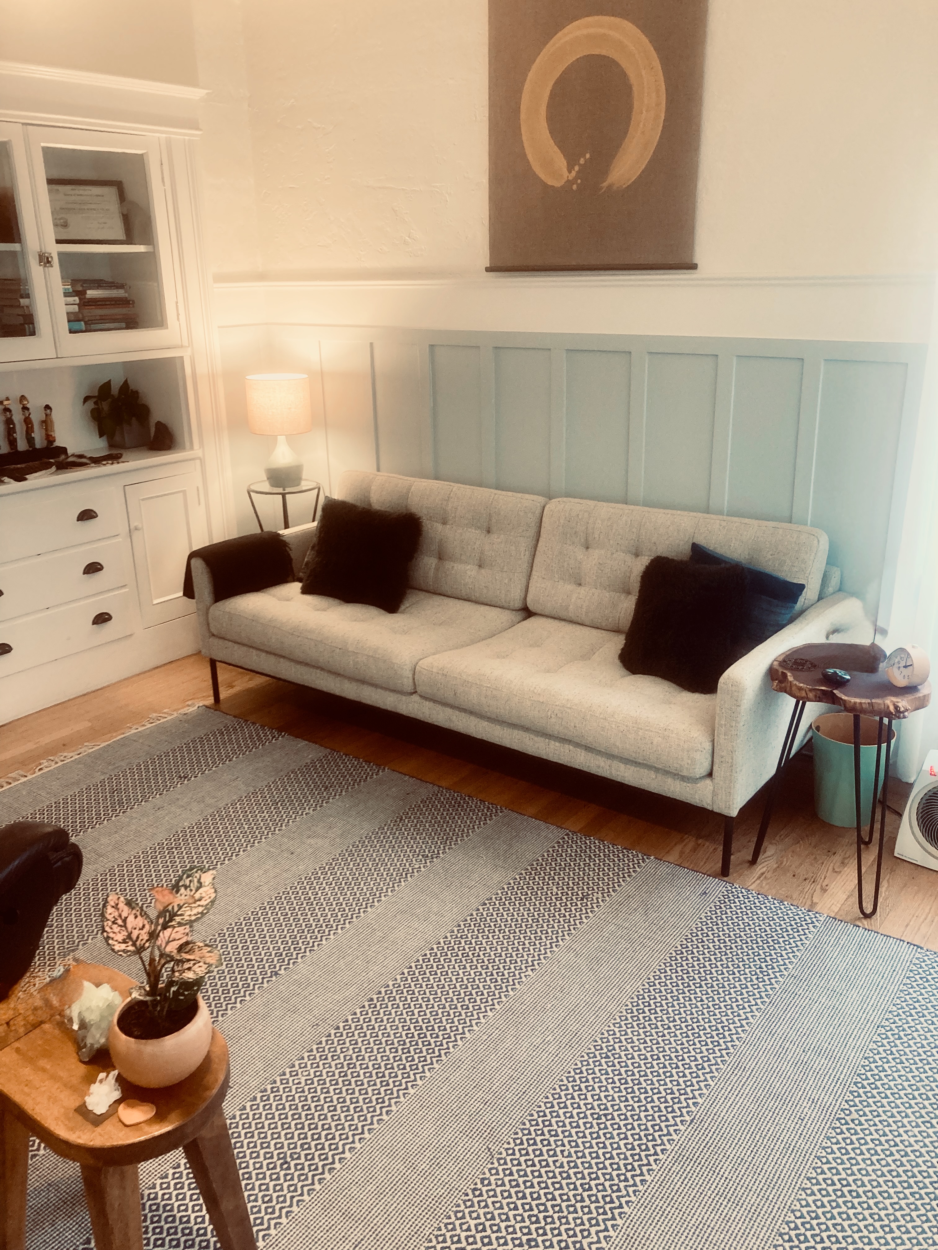 Therapy office interior with grey couch and enso painting
